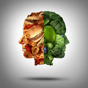 An illustration of a person's head split between leafy greens and junk food